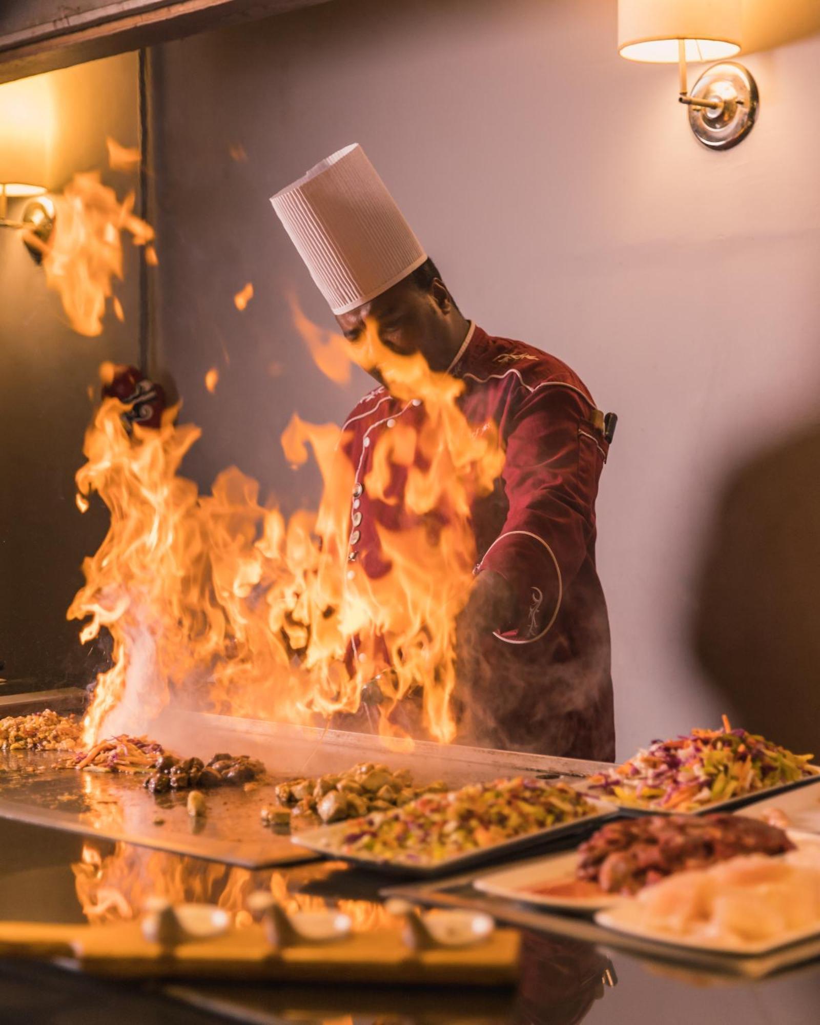 The Grand Resort ฮูร์กาดา ภายนอก รูปภาพ A chef cooking with a flaming torch